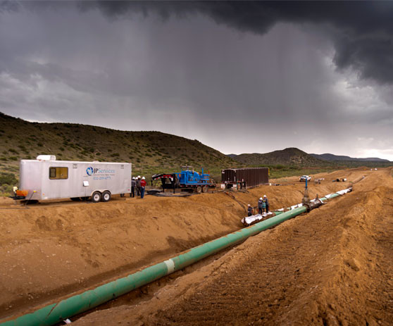 Sunbelt Equipment Marketing work site with a pip in a ditch and vehicles with trailers behind.