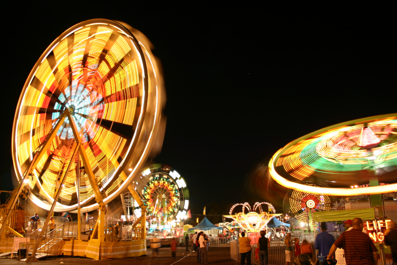 Tyler, Texas east texas fair ferris wheel and other rides lit up at night.