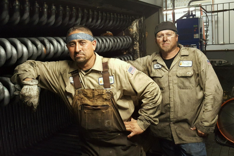 California Boiler employees standing against a large piece of equipment they are working on.