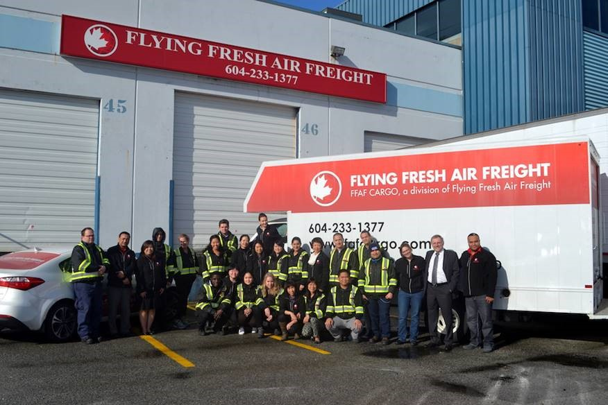 Flying Fresh Air Freight group photos by work truck and building.