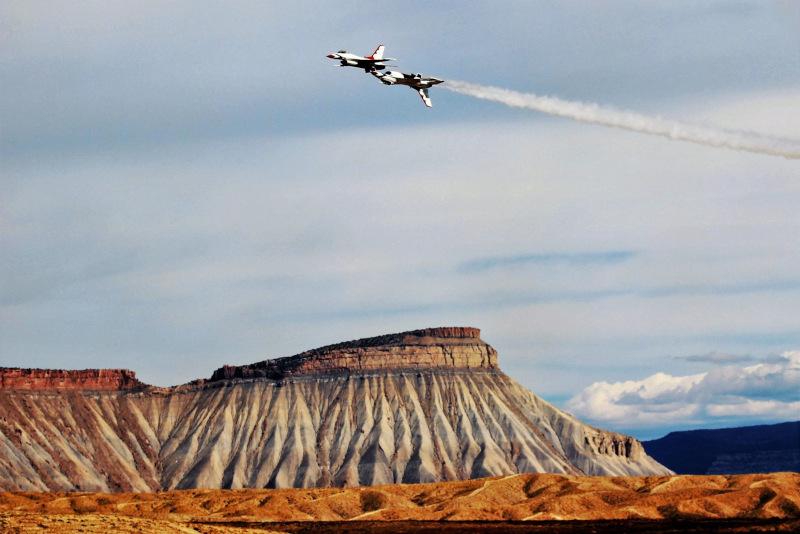 Grand Junction Regional Airport jets in the air doing a stunt with mountain in the background.