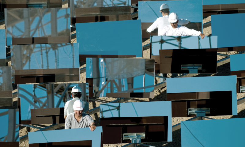 Lancaster, California men working on solar energy reflectors.