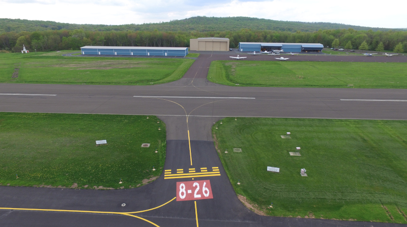 Pennridge Airport Runway from 8-26 showing hangars and small craft in the distance.