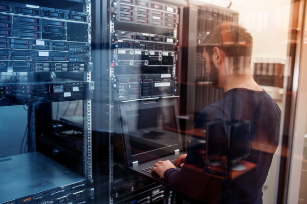 Worldwide Services employee using a laptop on a server.