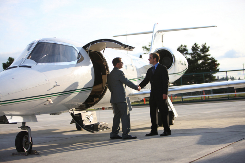 Texarkana Regional Airport corporate jet with two men in suits shaking hands.