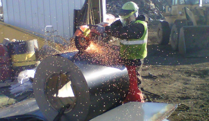 M. Gervich & Sons, Inc. employee using a demo saw on a roll of metal sheets.