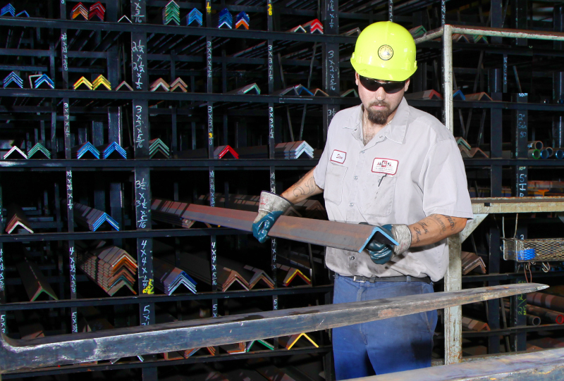 M. Gervich & Sons, Inc. employee grabbing a metal bar from a rack.