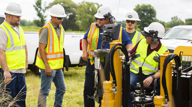 Vermeer Midwest men in the field with equipment, hard hats and safety vests.