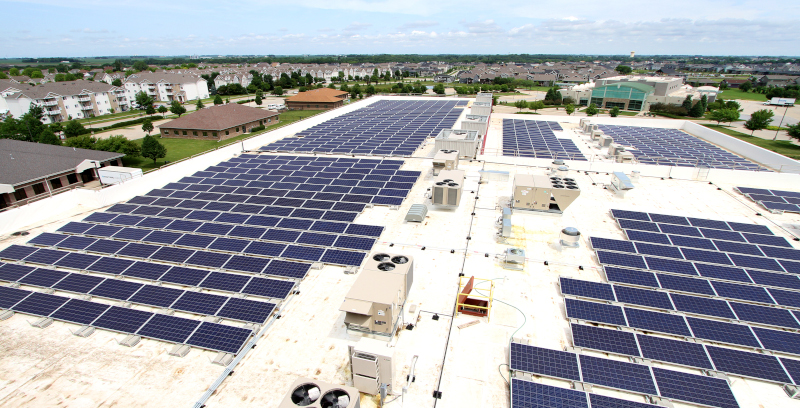 Waukee, Iowa Palm Theatres and IMAX plus solar initiative rooftop showing solar panels on a commercial building.