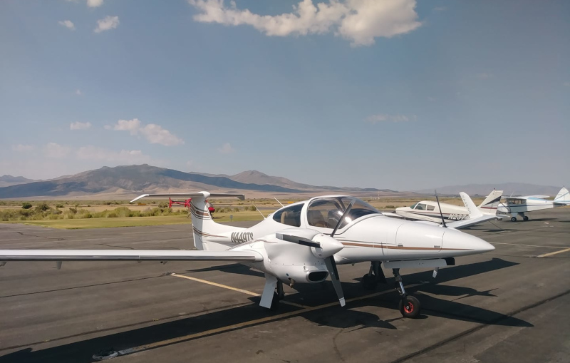 Winnemucca Municipal Airport airplanes on runway with mountains and sky behind.