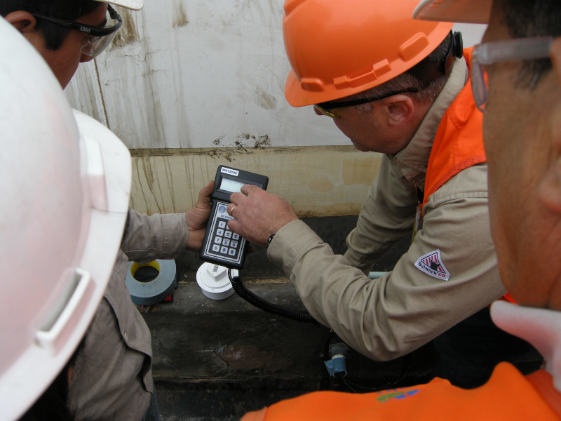 Zerust Oil & Gas workers looking at a readout on an instrument in the field.