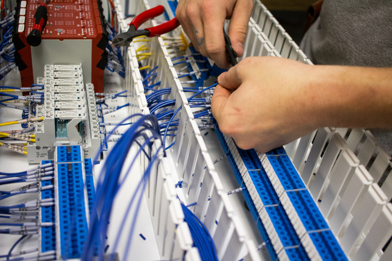 Fallas Automation Inc. worker adjusting wiring.