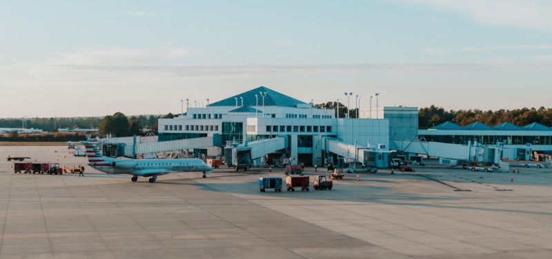 Columbia Metropolitan Airport terminal exterior with airplanes and service vehicles.