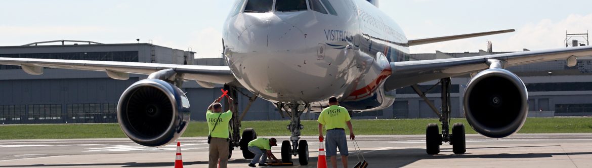 Hagerstown Regional Airport men directing a jet with hand signals and wheel chalks.