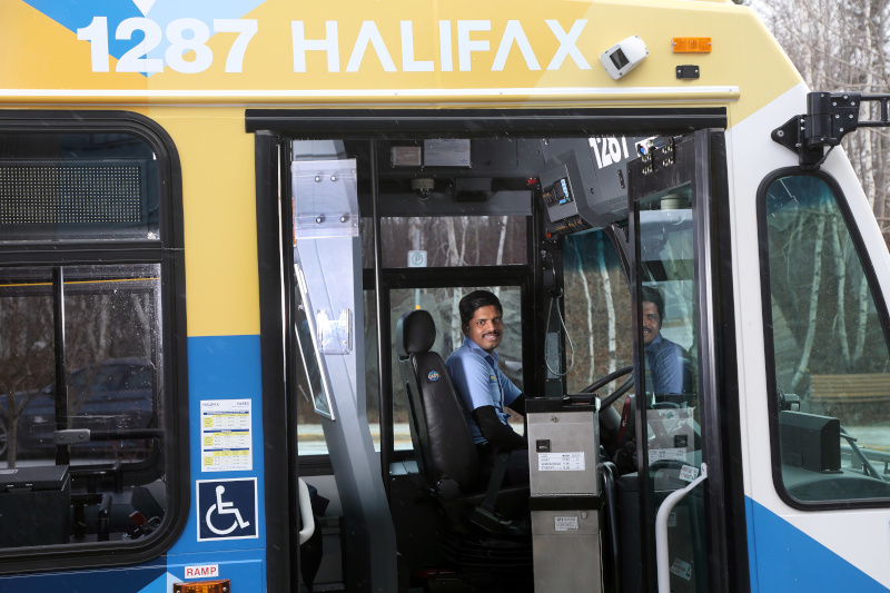 Halifax Transit bus employee with the bus door open smiling.