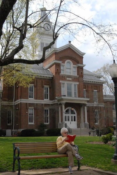 Simpson County, Kentucky courthouse with a person reading out front on a bench.