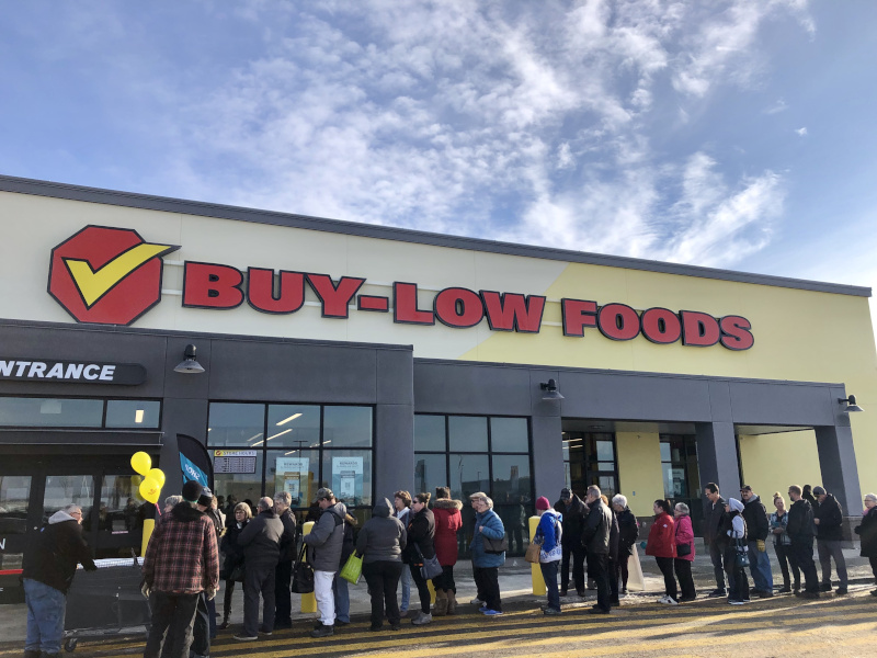Warman, Saskatchewan Buy Low Opening event with a line of people out front.
