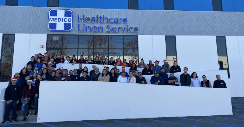 Medico Healthcare Linen Service Plant view holiday party, group photo showing employees out on the front ramp and steps.