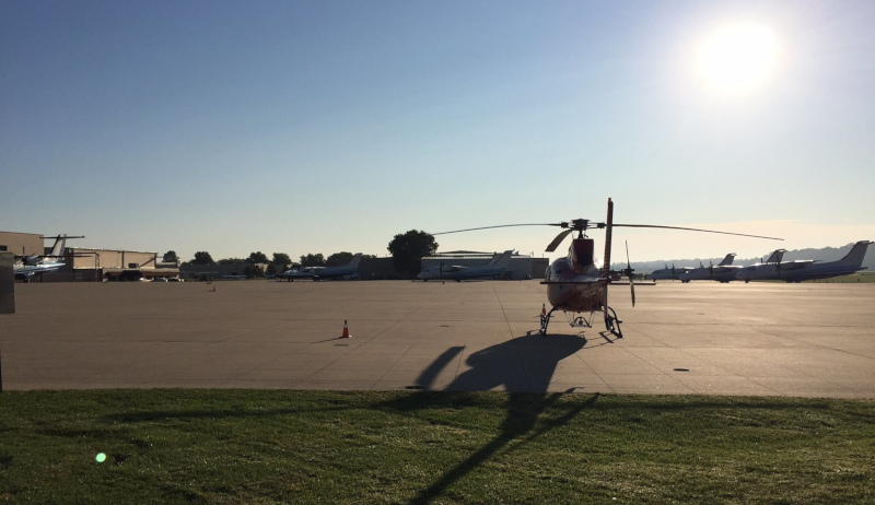 Spirit of St. Louis Airport helicopter parked with the sun behind.