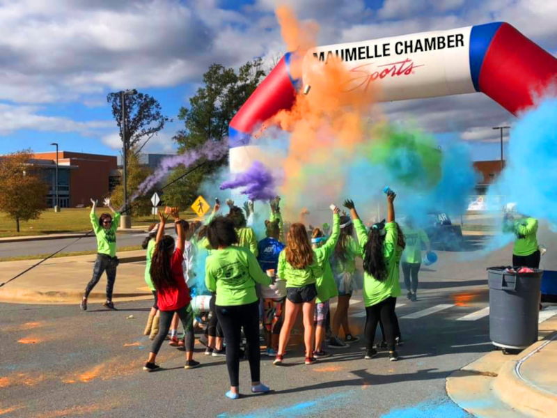 Maumelle, Arkansas event with colorful powder being thrown into the air.