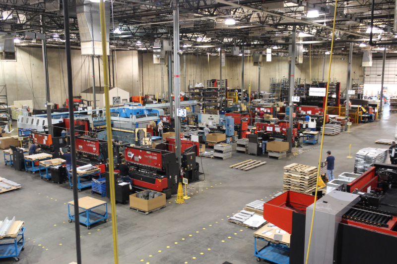 Special Products & Mfg., Inc. interior warehouse view showing work stations and people working.