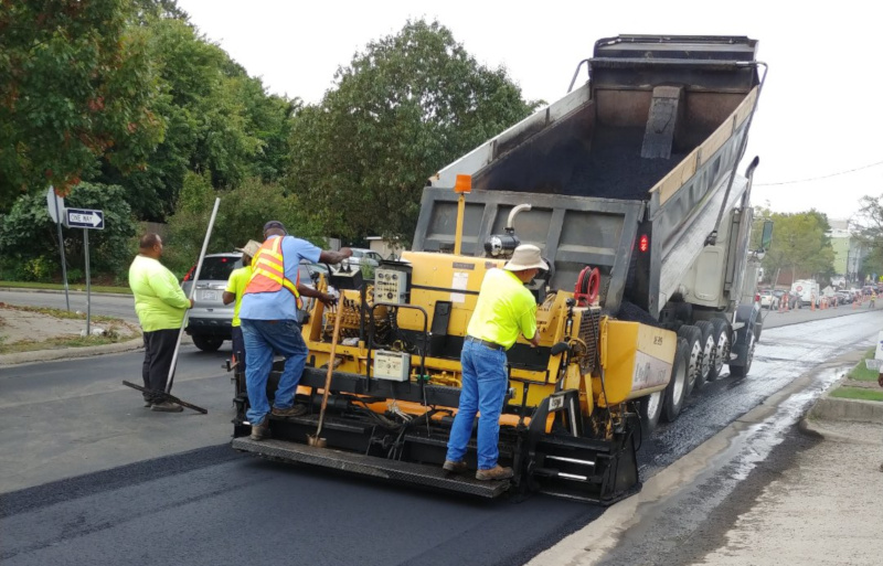 J.F. Wilkerson Contracting Company, Inc. employees at work with a dump truck paving a road.