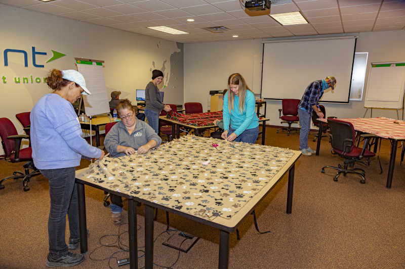 4Front Credit Union employees working on a quilt