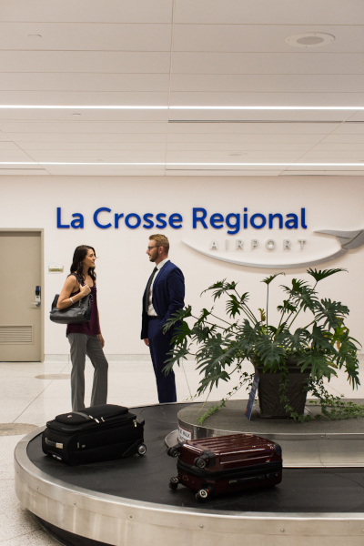 La Crosse Regional Airport terminal building interior with a man and woman talking near baggage claim