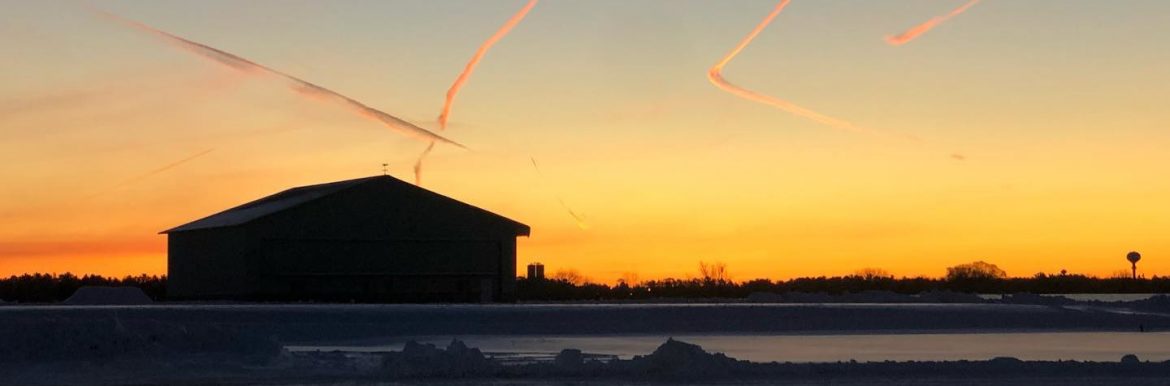Wausau Downtown Airport at sunset with contrails and snow
