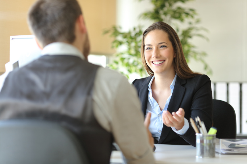 Happy executive coworkers laughing and talking at the office